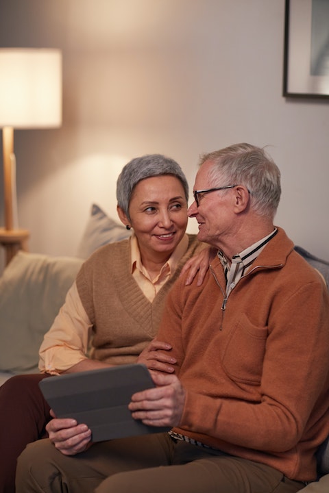 An older man and woman looking at an iPad
